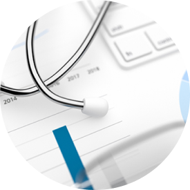 Stethoscope on top of financial charts and keyboard, symbolizing healthcare data analysis